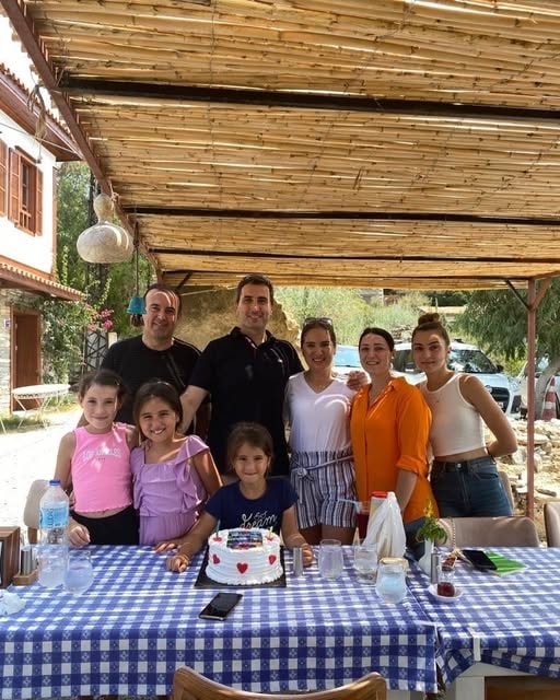 Aile grubu doğum günü pastasıyla açık hava pergola altında