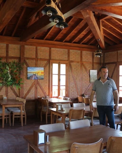 Restoran sahibi iç mekanda misafirleri karşılıyor